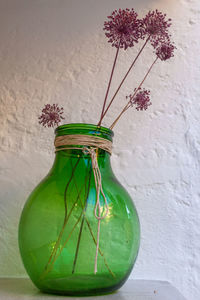 Close-up of vase on table against wall