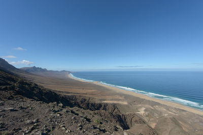 Scenic view of beach against blue sky