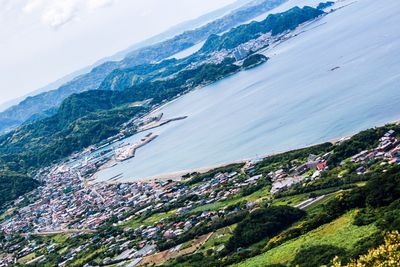 Scenic view of sea by mountains against sky
