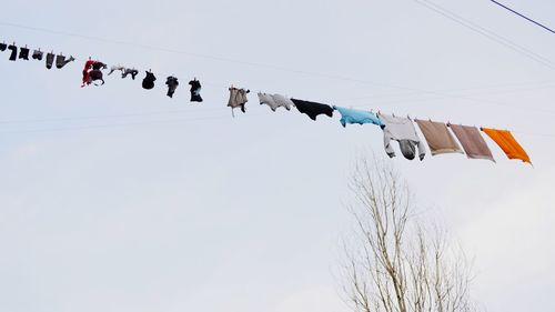 Low angle view of clothes drying against clear sky