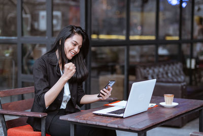 Businesswoman using laptop at cafe