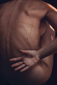 Midsection of shirtless man against gray background