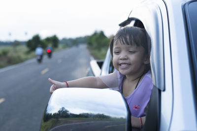 Portrait of young woman sitting in car