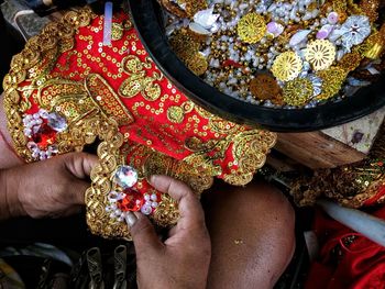 Cropped hands of woman embroidering fabric