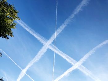 Low angle view of vapor trail against blue sky