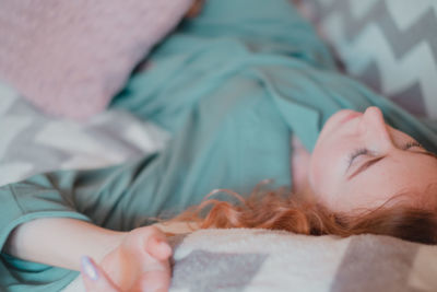 High angle view of young woman sleeping on bed at home