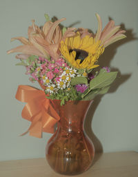 Close-up of flower vase on table against wall