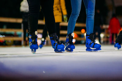 Low section of people skiing on ice rink