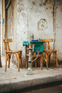 Hookah by wooden chairs and table on footpath