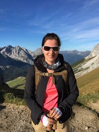 Portrait of mature man wearing sunglasses standing on mountain