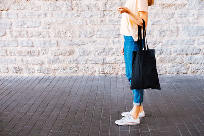 Low section of woman walking on footpath