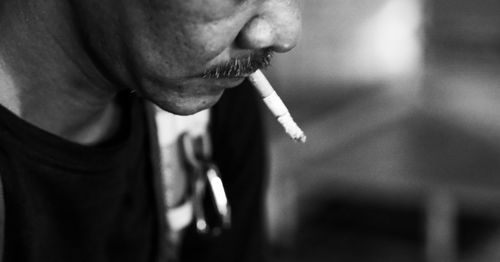 Close-up of man holding cigarette