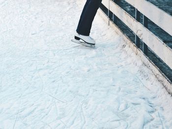 Low section of person wearing ice skates standing on field