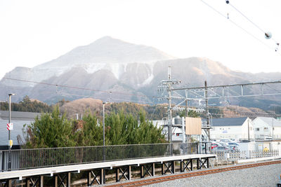 Panoramic view of railroad tracks by city against sky