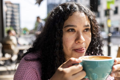 Young woman enjoying coffee on sunny day