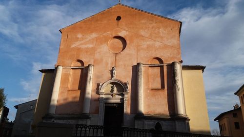 Low angle view of cross on building against sky