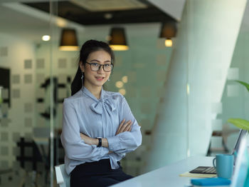 Portrait of smiling young woman sitting in office