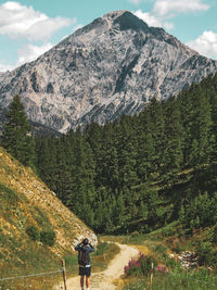 Rear view of man standing on mountain road