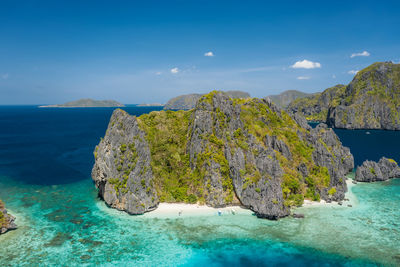 Scenic view of rocks in sea against blue sky