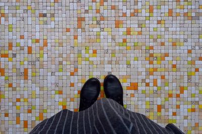 Low section of woman standing on patterned floor