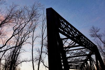 Low angle view of silhouette bridge against sky