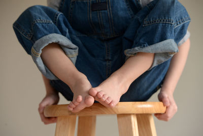 Low section of boy sitting on stool