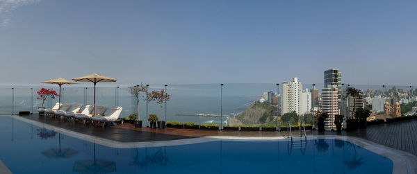 View of swimming pool by sea against clear sky