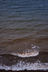 High angle view of waves rushing towards shore