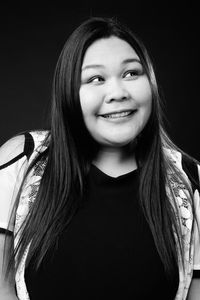 Woman standing against black background