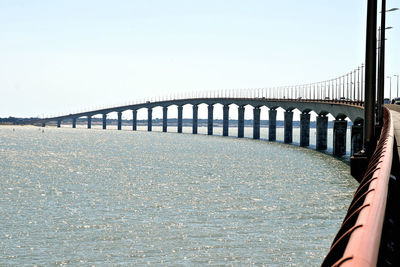 Bridge over sea against clear sky