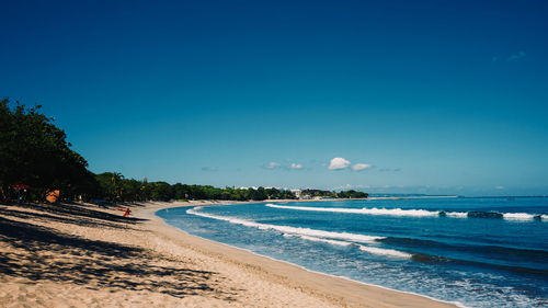 Scenic view of beach against blue sky