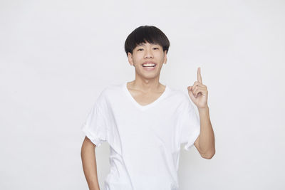 Portrait of smiling man standing against white background