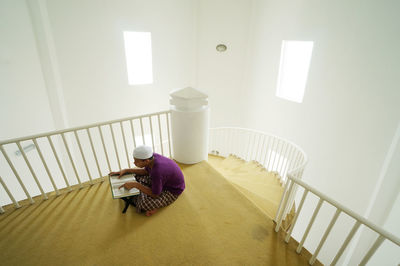 High angle view of person sitting on staircase at home