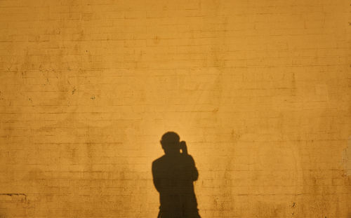 Shadow of man and woman standing against wall