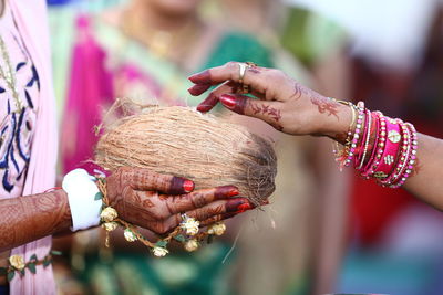 Close-up of woman holding hands against blurred background