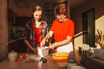 Woman holding food on table in kitchen