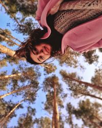Low angle view portrait of girl against trees