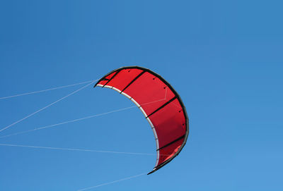 Low angle view of kite flying against clear blue sky
