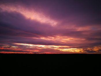 Silhouette landscape against sky at sunset