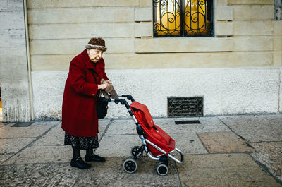 Full length of woman standing against wall