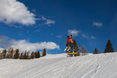 Man riding motorcycle on snow covered mountain against sky