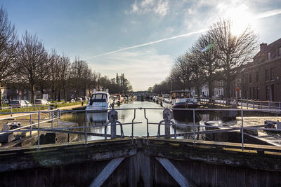 Scenic view of canal in city against sky