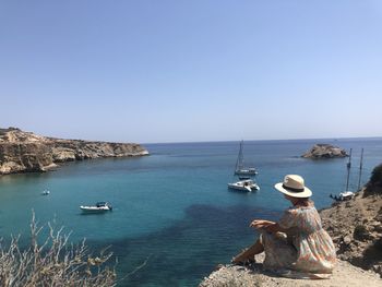 Sailboats in sea against clear sky
