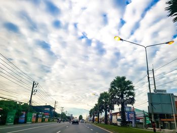 Low angle view of street against cloudy sky