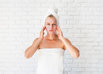 Portrait of mid adult woman standing against wall