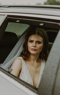 Portrait of young woman sitting in car