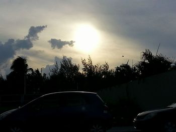 Cars on road against cloudy sky