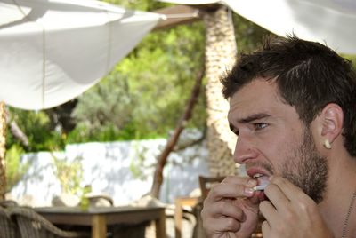 Portrait of young man drinking outdoors