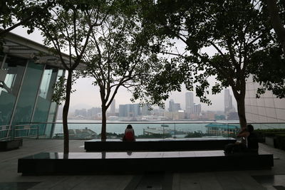 Rear view of woman sitting on bench in swimming pool