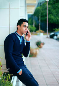 Man talking on mobile phone in city